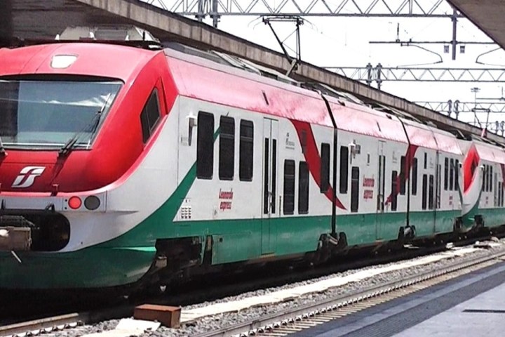 a green train parked at a station